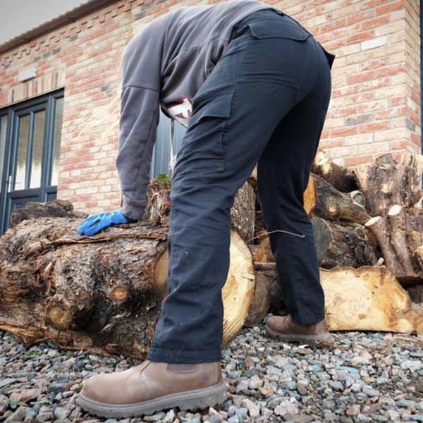 Michelle wearing Crafter trousers lifting logs